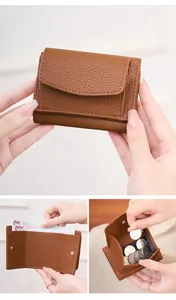 Detail view of brown lychee leather RFID wallet with button coin pocket and banknote slot