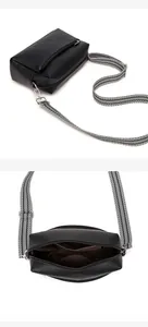 Detail of vintage black soft leather crossbody bag showing striped strap and inner lining