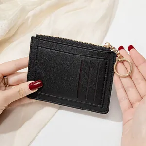 Détail d'un porte-cartes en cuir PU noir avec fermeture éclair dorée et porte-clés