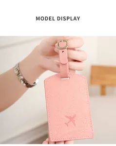 Close-up of pink faux leather luggage tag with embossed airplane and gold buckle strap