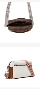 Detail of vintage soft leather crossbody bag with wide woven strap and silver hardware