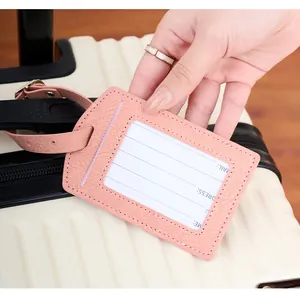 Detailed view of pink PU leather luggage tag with contact info card on suitcase
