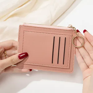 Détail d'un porte-cartes rose lotus avec trois fentes et un anneau porte-clés doré