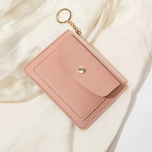 Détail du portefeuille rose en similicuir avec zip doré, bouton-pression et porte-clés