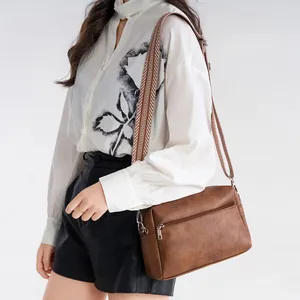 Retro soft leather crossbody bag with brown color and wide patterned shoulder strap