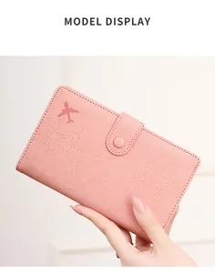 Detailed view of pink RFID passport holder with airplane logo and snap closure