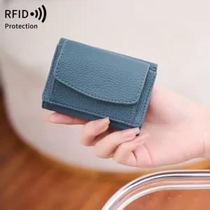 Blue RFID leather mini wallet with litchi grain texture held in hand for size display