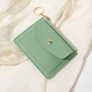 Détail du portefeuille mince vert menthe avec bouton-pression doré, fermeture et porte-clés