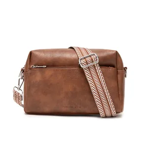 Brown vintage faux leather crossbody bag with a red and white geometric woven wide strap