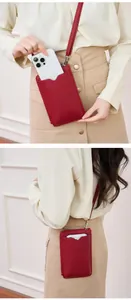 Detailed view of red lychee pattern leather phone bag with slim shoulder strap and zipper