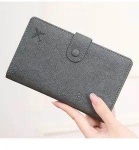 Detail of RFID blocking passport holder with pebbled leather texture and airplane embossed logo