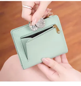 Close-up of mint green leather wallet featuring litchi texture and golden heart zipper