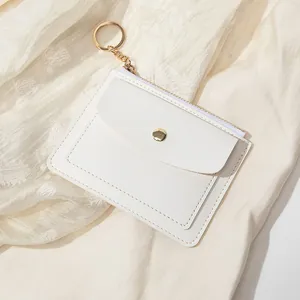 Gros plan du portefeuille en cuir PU blanc avec bouton-pression doré et anneau métallique