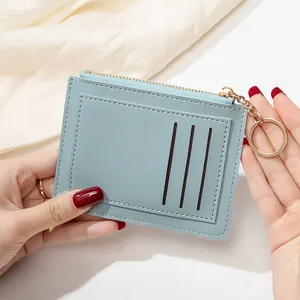 Détail de l'étui à cartes en cuir bleu clair avec fermeture éclair et porte-clés