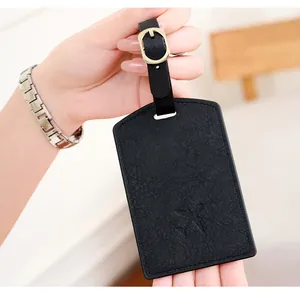 Close-up of black PU leather luggage tag with aircraft icon and adjustable strap