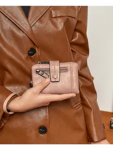 Detail of light pink RFID wallet showing zipper compartment and snap closure stitching