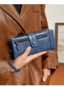 Detail of blue leather RFID wallet featuring dual zippers, wrist strap, and snap closure