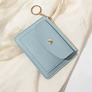 Détail d'un porte-cartes en similicuir bleu clair avec zip doré et porte-clés intégré