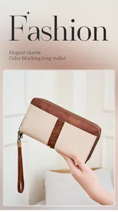 Dettaglio del portafoglio lungo bicolore con cuciture a croce e cinturino da polso