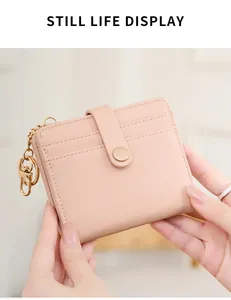 Detail view of the pink faux leather RFID wallet texture and gold chain keychain