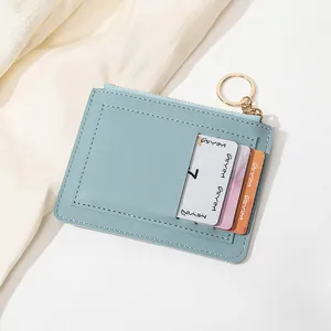Détail d'un porte-cartes en cuir PU bleu clair avec porte-clés doré et zip