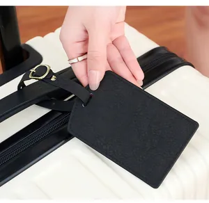 Close-up of black PU leather luggage tag with airplane debossing on suitcase