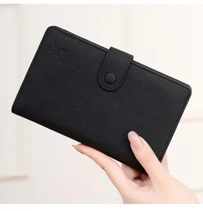 Detail of black RFID leather passport wallet with butterfly logo and buckle closure
