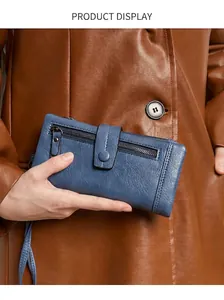 Close-up of deep blue RFID long leather wallet with zipper pocket and snap closure strap