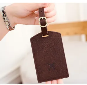 Detail of dark brown PU leather luggage tag featuring an airplane logo and metal buckle
