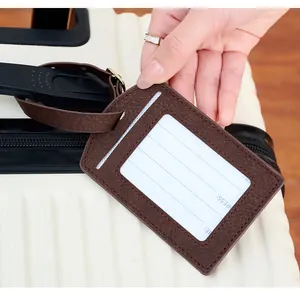 Close-up of deep brown PU leather luggage tag with lychee texture and adjustable strap