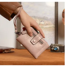 Detail of dusty pink RFID wallet with lychee texture and wrist strap on vintage background