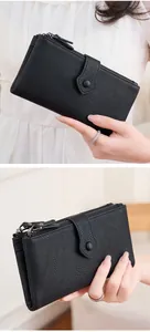 Dettaglio portafoglio lungo nero in pelle martellata con doppia zip e cinturino a fibbia