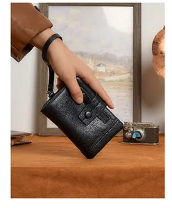 Detail of black pebbled leather RFID wallet with wrist strap and vintage metal snap button