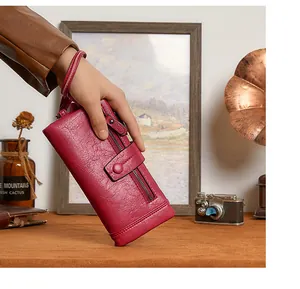 Detail view of deep red RFID long leather wallet with litchi texture and wrist strap