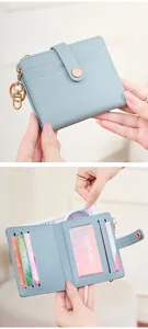 Detail view of light blue bifold RFID wallet with multiple card slots and gold keychain