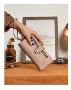 Detail of pink RFID wallet with lychee leather texture and wrist strap on vintage background