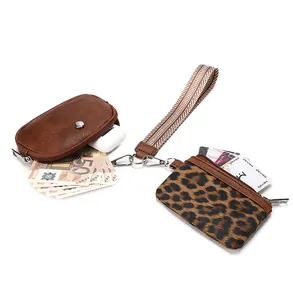 Detail of vintage patterned wristlet wallet with coins, cards and wireless earbuds