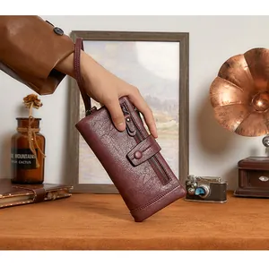 Detail view of burgundy long wallet with retro leather texture and wrist strap