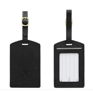 Detail of black PU leather luggage tag with adjustable gold buckle and aircraft logo