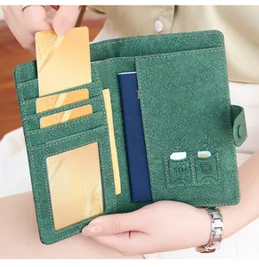 Detail of dark green pebble leather passport holder with SIM slots and multi-card pockets