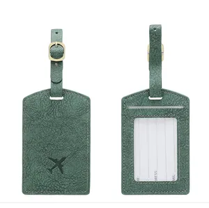 Detail view of dark green PU leather luggage tag showing front plane icon and back ID card