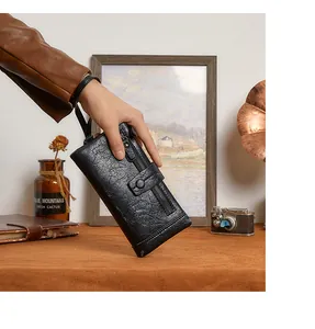 Macro view of long black RFID wallet with wrist strap and textured faux leather finish
