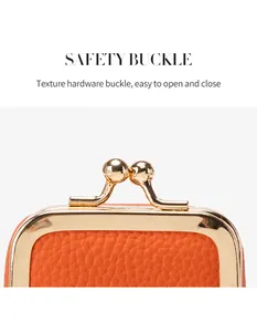 Gros plan sur la pochette à bijoux en cuir orange avec fermoir métallique doré sécurisé
