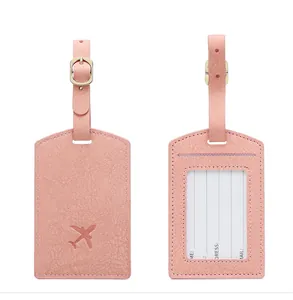 Detail of pink PU leather luggage tag with adjustable strap and personal info card
