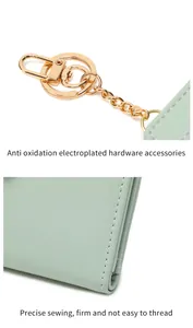 Detail of mint green leather wallet featuring gold hardware clasp and fine stitching