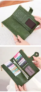Detail of dark green leather wallet showing multiple card slots and secure zip pocket