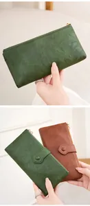 Detail view of double zipper long wallets in dark green and caramel vintage textured leather