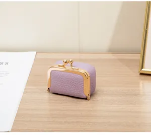 Vue détaillée d'une mini boîte à bijoux lilas avec cadre doré sur une table en bois