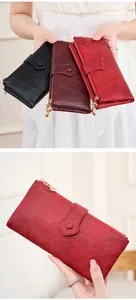 Detail of multi-color long leather wallets with dual zippers and gold orb pendants