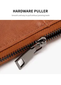 Macro view of gunmetal zipper puller and smooth hardware on brown grain leather wallet